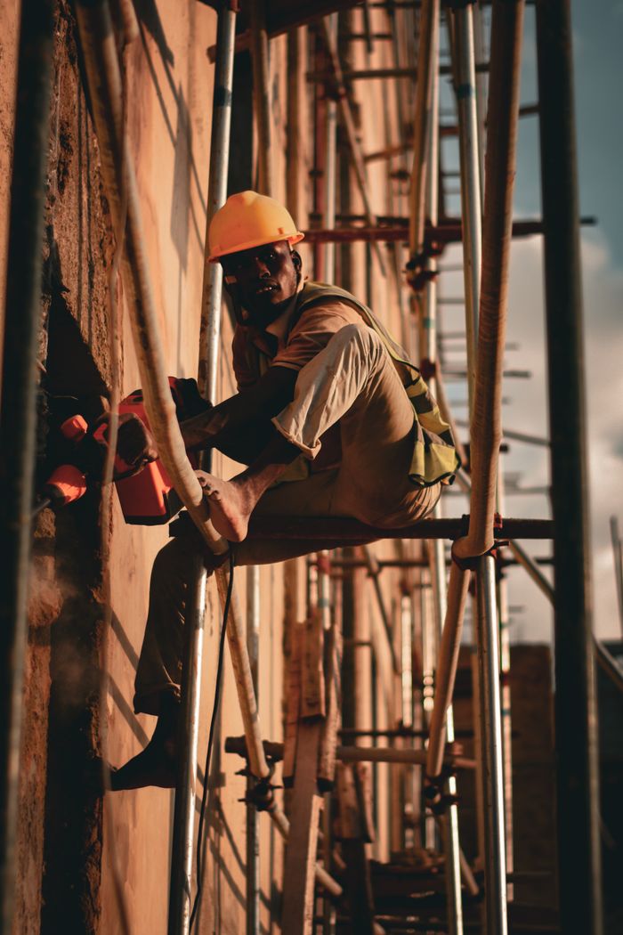 Dramatic portrait of a construction worker on scaffolding during the day.